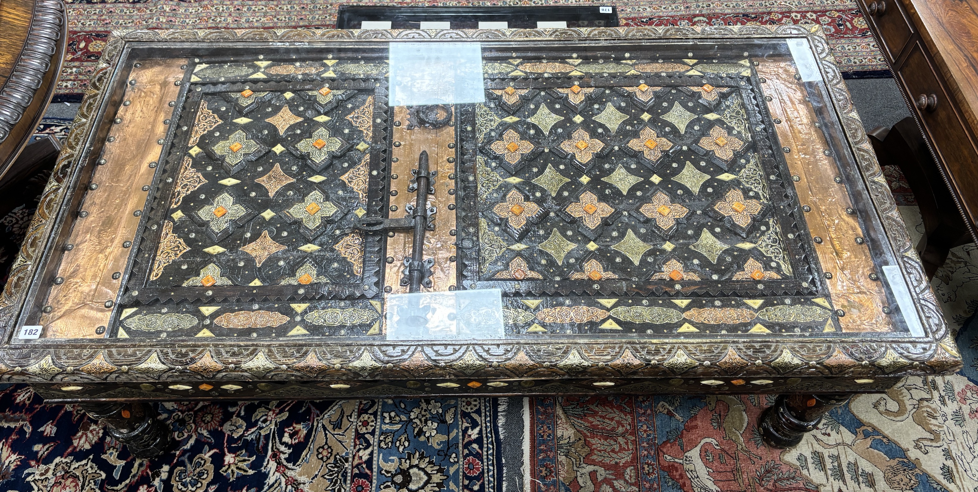 A copper mounted Moroccan door, now as a coffee table, width 153cm, depth 78cm, height 57cm
